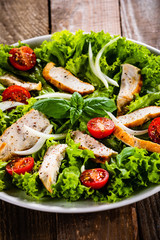 Caesar salad on white plate on wooden table