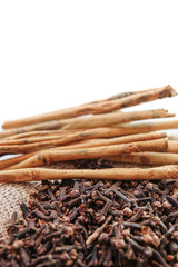 cloves and cinnamon on burlap sacks isolated white