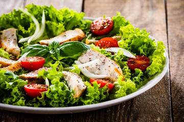 Caesar salad on white plate on wooden table