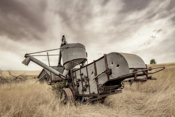 Fototapeta premium Antique combine left if a field to rot in Norther Idaho farm country