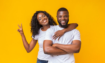 Fototapeta premium Happy young couple posing over yellow studio background