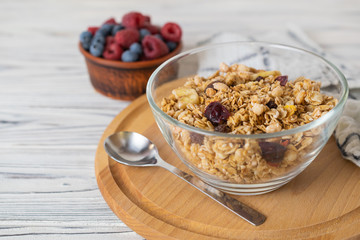 Homemade granola with raisins, nuts and berries in a glass bowl