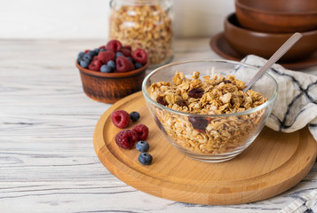 Homemade granola with raisins, nuts and berries in a glass bowl