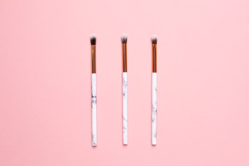 Beauty make up brushes on a pink background