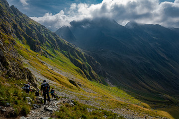 Tourists walking on the path from the top of the mountain. Fagaras Mountains, Romania