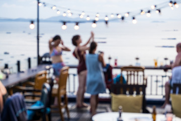 shot of young people toasting drinks at a rooftop party. Blur Abstract Background.