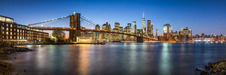 Manhattan skyline panorama with Brooklyn Bridge at night