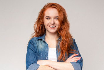 Cute redhead teen posing to camera with folded arms