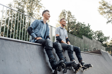 Roller skating, two skaters sitting on the ramp