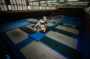 Boy making flip on the trampoline in the gym