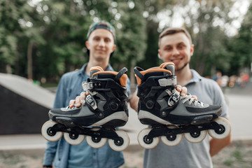Roller skating, two skaters holds skates in hands