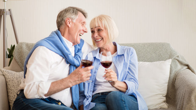 Loving senior couple drinking wine at home - Powered by Adobe