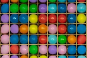 Multi-colored balls on a wooden bench. Game of throwing darts into balls, fun in the park. The concept of entertainment and fun. Fun leisure activities. Abstract festive background.
