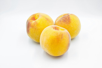 image of three peaches with a white background