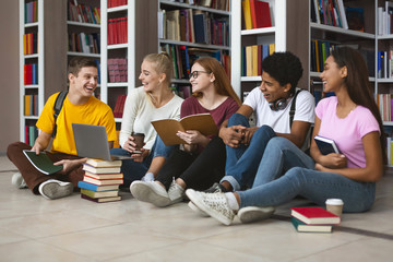 Group of teenage students making homework and smiling