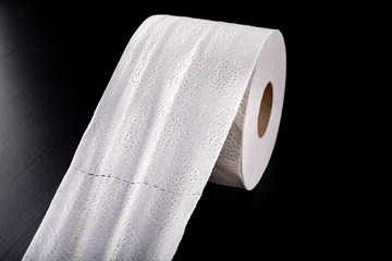 White soft toilet paper on a dark table. Personal hygiene accessories.