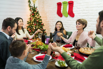 Fototapeta na wymiar Family Praying During Christmas Dinner At Home