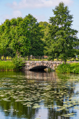 Fototapeta na wymiar Old stone bridge reflected in a pond