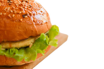 Close-up vegetarian burger  Isolated on a white background with sesame seeds, artificial meat, green lettuce.  Selected focus