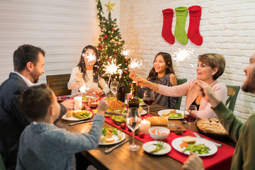 Family Lighting Sparklers While Having Meal At Home