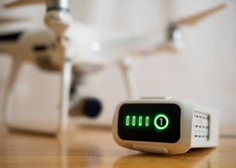 Drone intelligent lithium-polymer battery charging on wood desk with UAV aircraft in background.