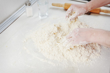 Hands chef knead dough for pizza. Knead dough with your hands. Woman's hands knead dough. Cooking pizza.