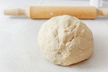 Dough with rolling pin. Flour on the table. Pizza dough. Rolling pin for the test.