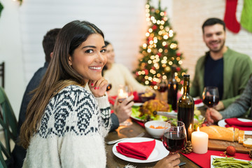 Latin Woman With Friends In Christmas Party At Home