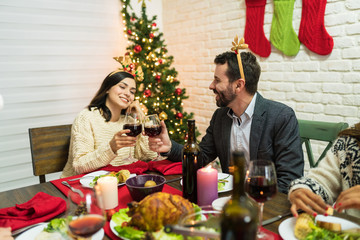 Happy Couple Clinking Wineglasses At Christmas Party