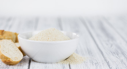 Some fresh Bread Crumbs on wooden background (selective focus; close-up shot)