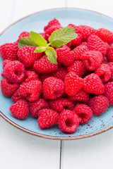 Fresh raspberries in a plate on a  vintage background.