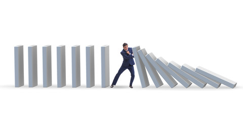 Businessman preventing domino effect in business concept