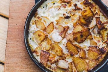 Potatoes baked with meat in the oven. Delicious dinner recipe. Potato pudding. Baked potato. Beef casserole. Potato gratin.Baked potatoes with eggs and chicken in a round bowl on a wooden table