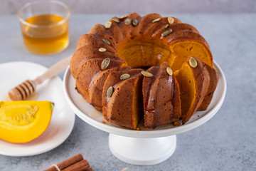 Pumpkin cake with honey on a gray background. Copy space.