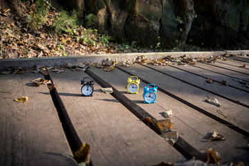 Vintage black alarm clock on autumn leaves. Time change abstract photo. Daylight saving time.