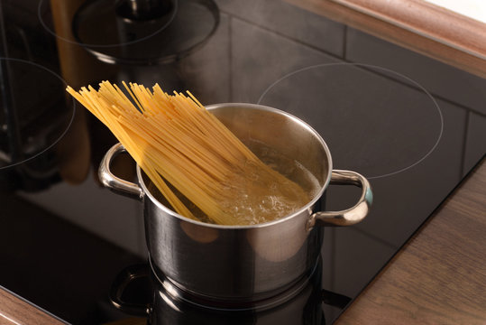 Spaghetti in a pot in boiling water on a stove