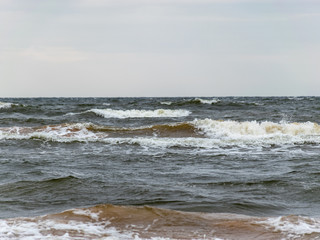 Big breaking sea wave on a sandy beach on the Baltic Sea