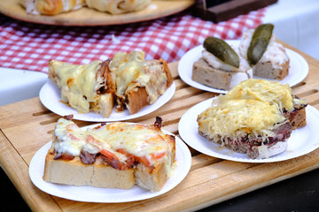 Plates with different tasty rustic sandwiches on a table in outdoor cafe.