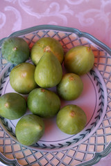 Ripe sweet figs. Figs fruit on a plate close up/macro. Healthy mediterranean fig fruit. Top view. Selective focus on the top figs slice in the bowl. Cut figs. Sliced fresh fruits.
