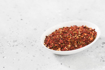 Set of spices for marinating kebab in a white bowl on a wooden table