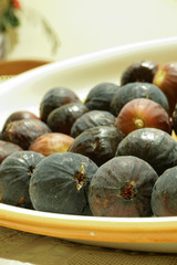 Ripe sweet figs. Figs fruit on a plate close up/macro. Healthy mediterranean fig fruit. Top view. Selective focus on the top figs slice in the bowl. Cut figs. Sliced fresh fruits.