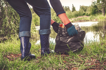 Recycle waste litter rubbish garbage trash junk clean training. Nature cleaning, volunteer ecology green concept. Young woman pick up spring forest at sunset . Environment plastic pollution