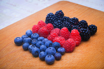 Background of fresh fruits and berries. Ripe blackberries, blueberries, plums, raspberries. Mix berries and fruits. Top view. Background berries and fruits. Black-blue and red food.