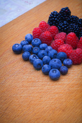 Background of fresh fruits and berries. Ripe blackberries, blueberries, plums, raspberries. Mix berries and fruits. Top view. Background berries and fruits. Black-blue and red food.