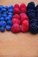 Background of fresh fruits and berries. Ripe blackberries, blueberries, plums, raspberries. Mix berries and fruits. Top view. Background berries and fruits. Black-blue and red food.