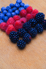 Background of fresh fruits and berries. Ripe blackberries, blueberries, plums, raspberries. Mix berries and fruits. Top view. Background berries and fruits. Black-blue and red food.