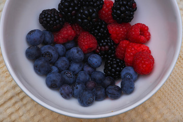 Background of fresh fruits and berries. Ripe blackberries, blueberries, plums, raspberries. Mix berries and fruits. Top view. Background berries and fruits. Black-blue and red food.