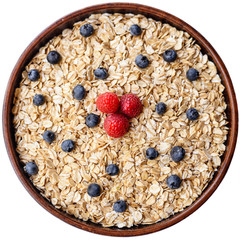 Oat flake in a bowl with fresh berries surface top view, diet concept.
