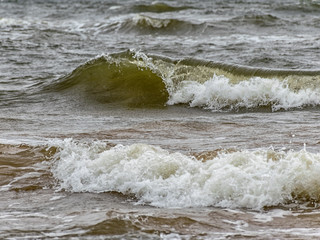 Big breaking sea wave on a sandy beach on the Baltic Sea