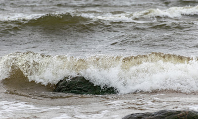 Big breaking sea wave on a sandy beach on the Baltic Sea